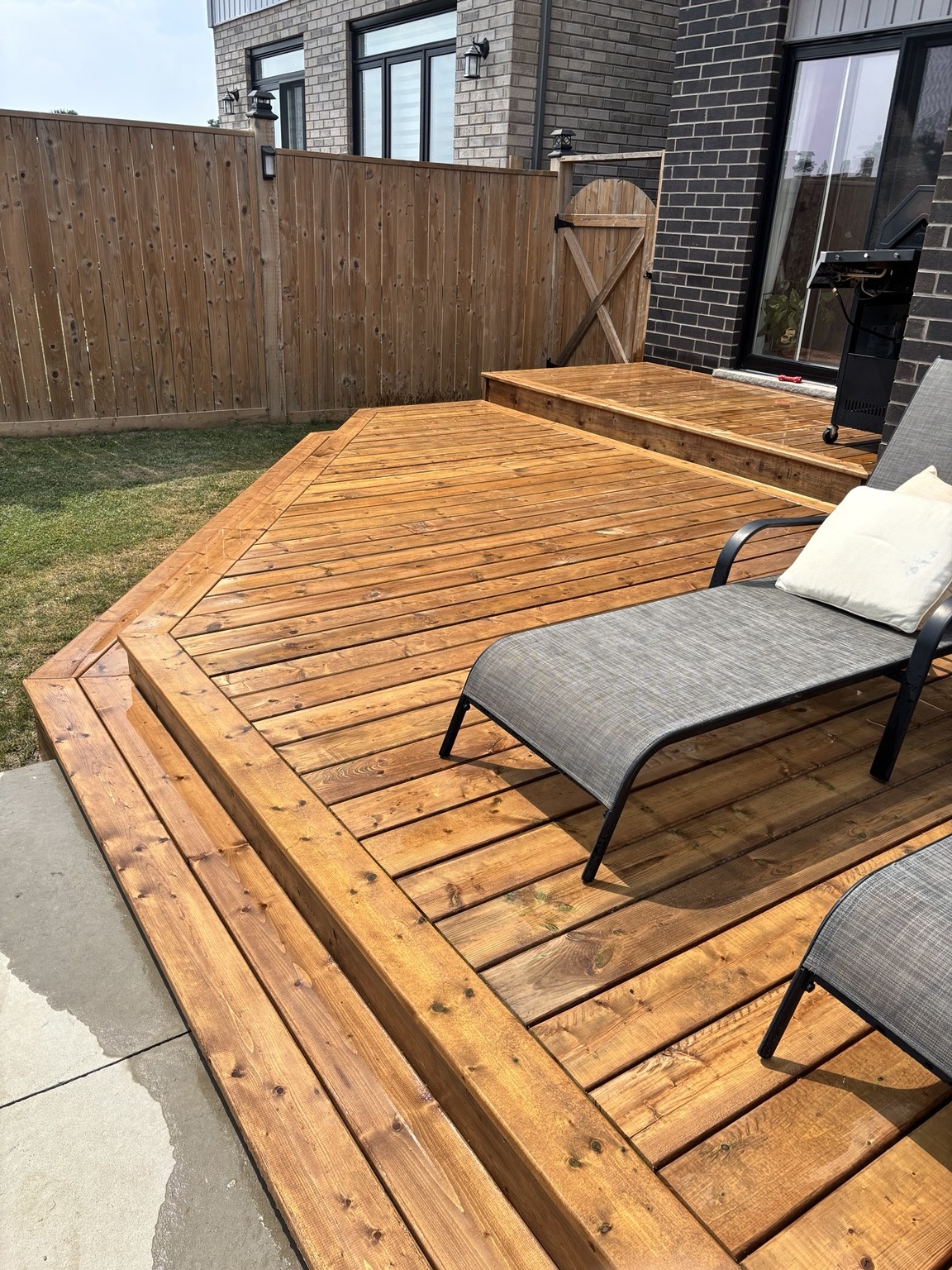 A stepped wood deck with a framed perimeter and space to relax.