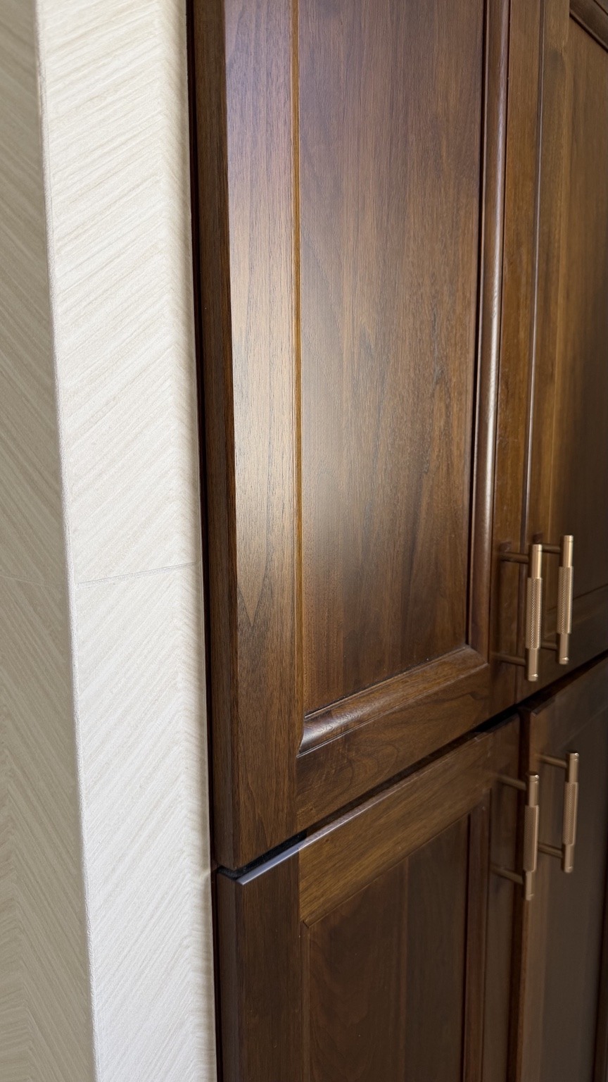 Rich wood cabinetry alongside textured tile.